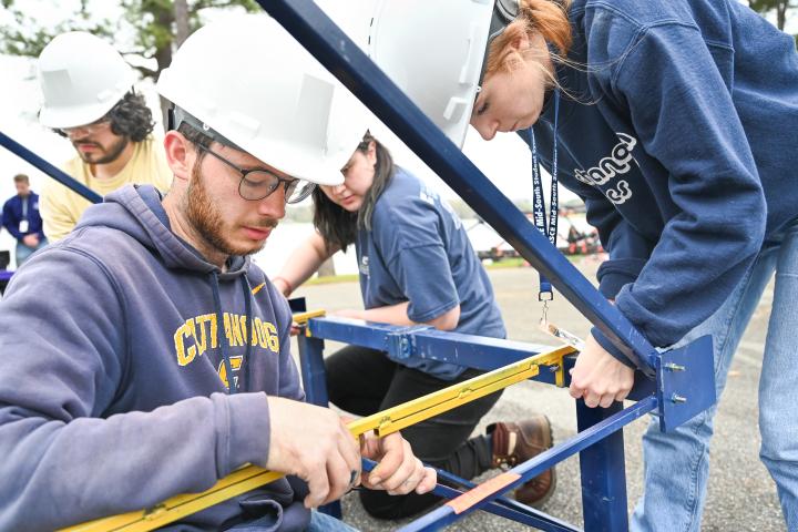 Engineering students building a steel bridge