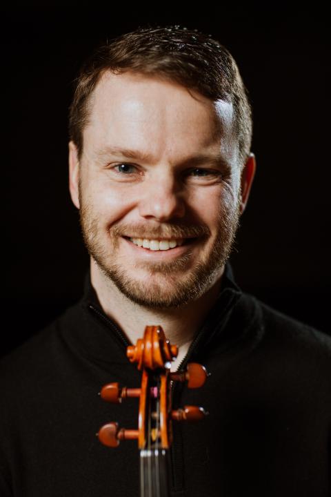 Headshot of Josh Holritz with violin