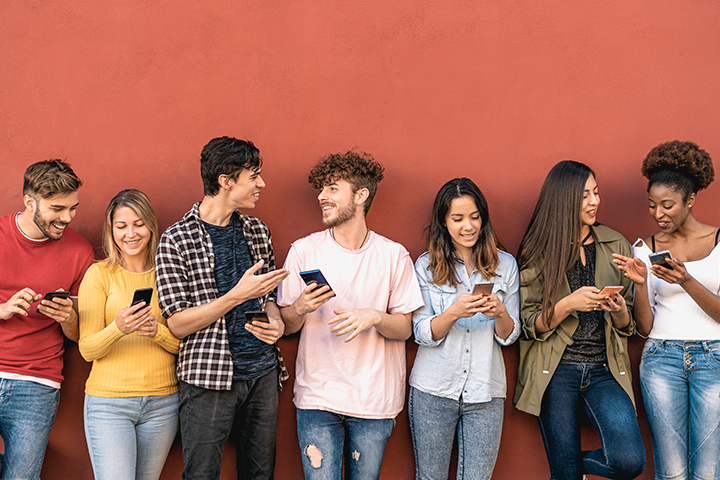 Photograph of a diverse group of college students looking at their phones.