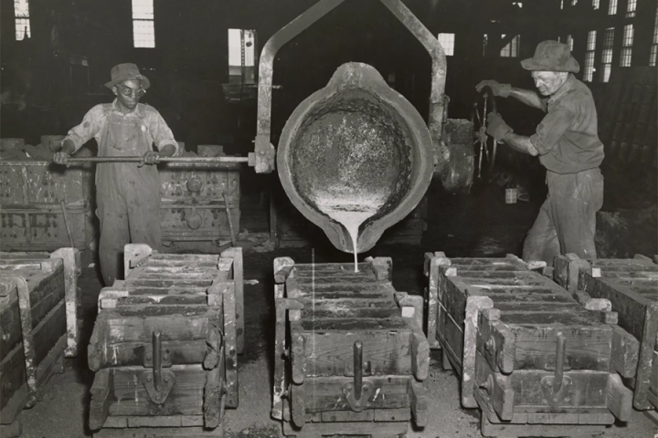 Wheland Foundry, 1950 Two men are pouring molten metal into molds at Wheland Foundry in 1950.