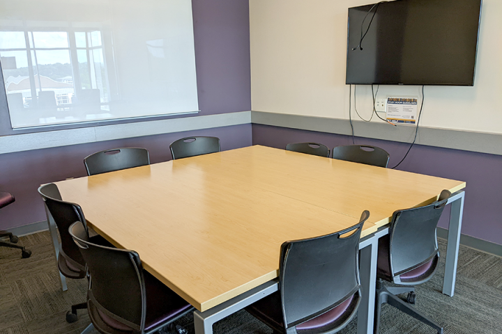 Photograph of a medium study room showing whiteboard, LCD screen and furniture arrangement