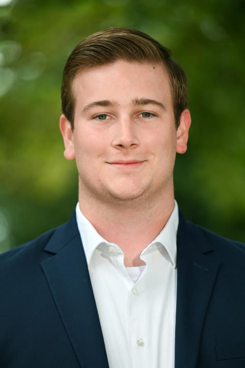 Profile photo of Harrison Davis in a white shirt and navy blue jacket.