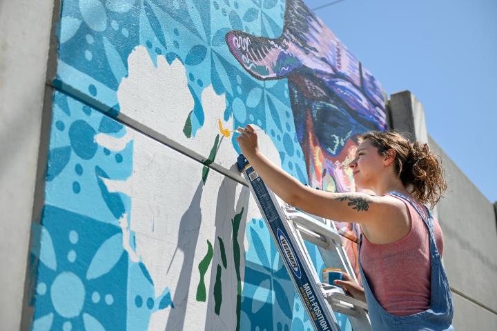 Female student painting a mural 