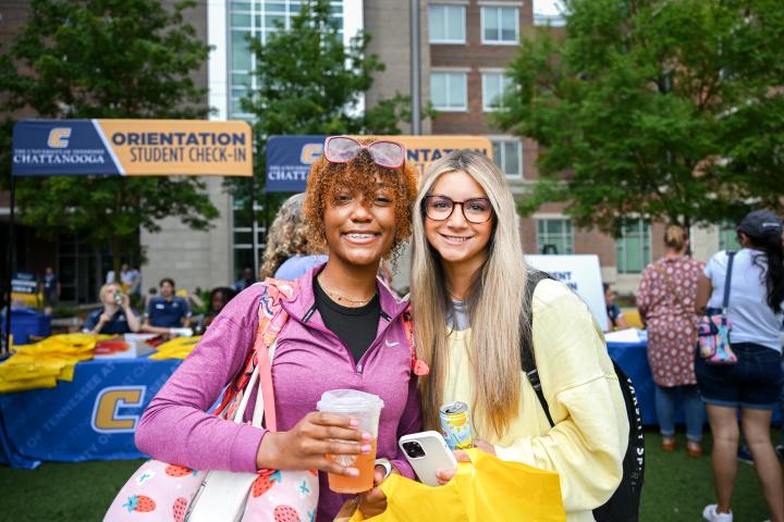 Two female students in front of the student orientation booths
