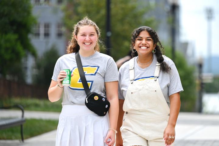 Two female students walking across campus
