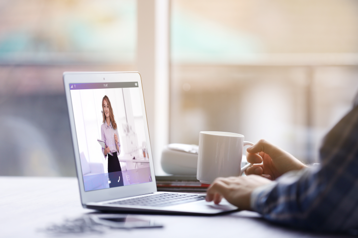 Photograph of a person in an online meeting on their laptop