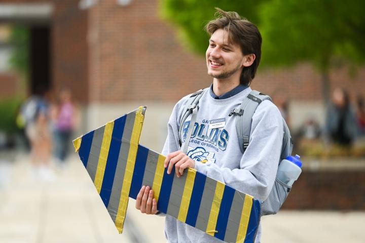 UTC Transfer Student UTC student holding a blue, gray, and gold stripped arrow sign
