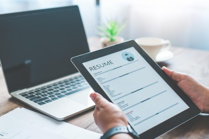 Resume review Employer reviewing a resume using a tablet computer.