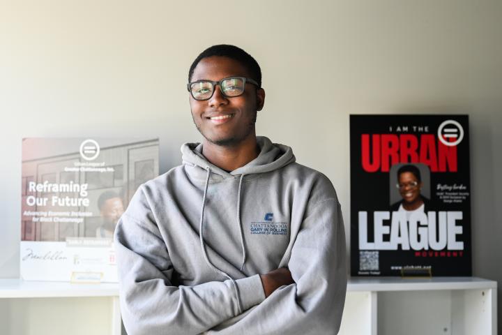 Intern crossing arms at Urban League wearing Gray Rollins College of Business hoodie