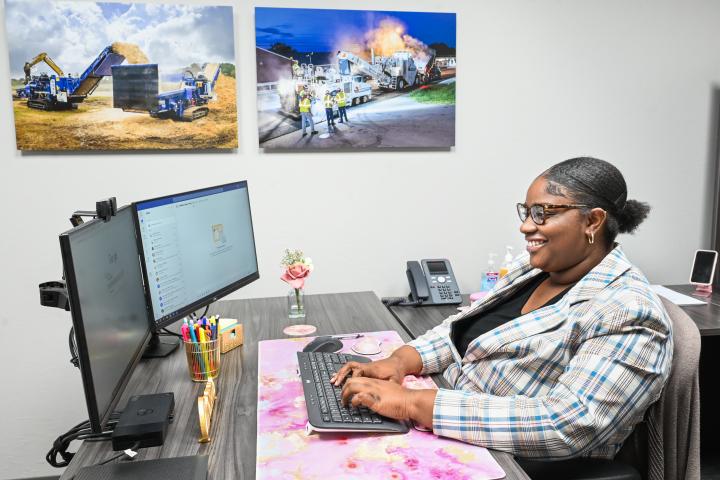 Smiling student intern at desk typing