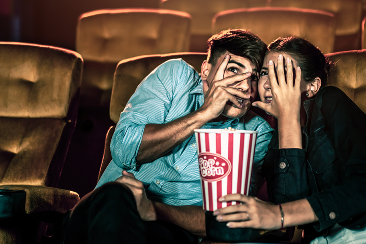 Photo of two people afraid to look at the movie screen Photo of two people afraid to look at the movie screen