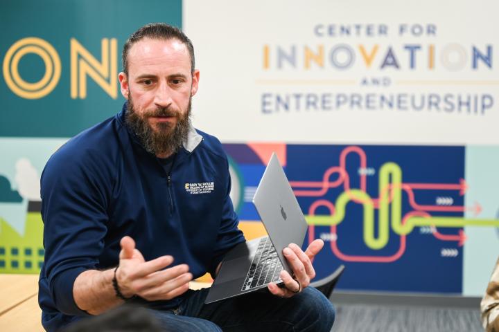 Professor giving lecture with laptop in hand