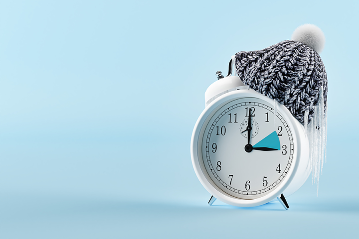 A clock wearing a winter hat