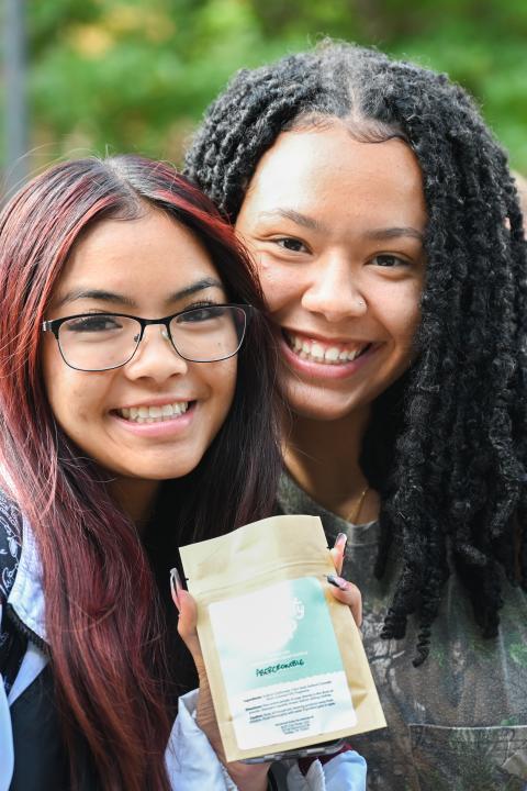 UTC students smiling and holding up a product
