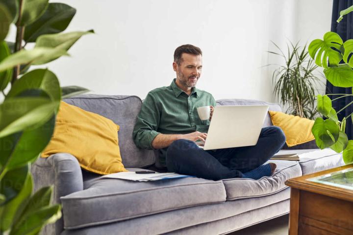 man with laptop on sofa