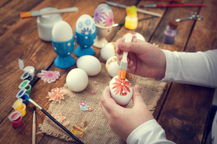 A person decoupaging designs onto eggs