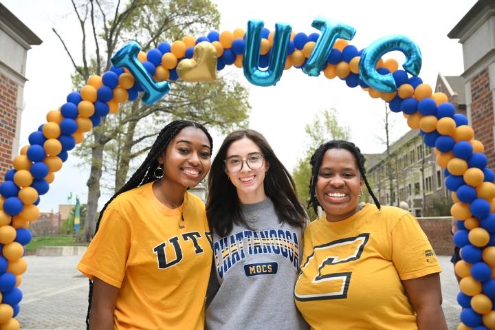 UTC students standing under a balloon arch with balloons that read "I heart UTC"
