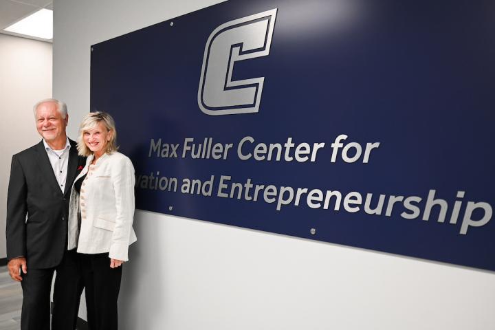 Max Fuller standing in front of sign that says Max Fuller Center for Innovation and Entrepreneurship
