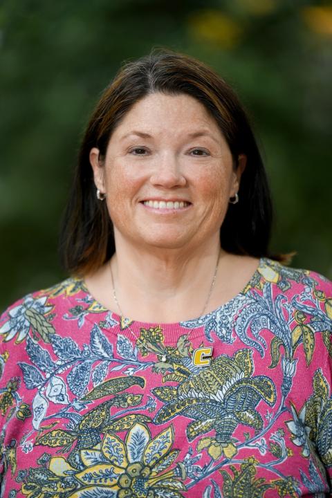 Headshot of Gretchen Potts in a multicolored patterned shirt 