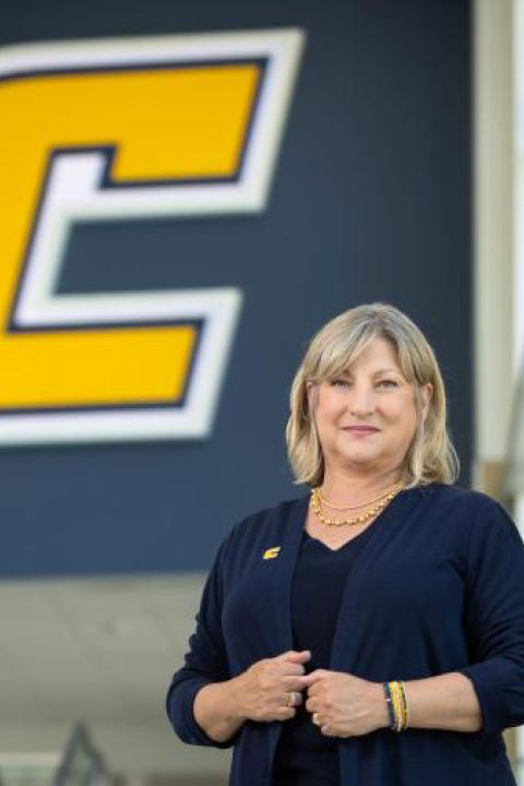 Chancellor Lori Bruce in front of a power C banner