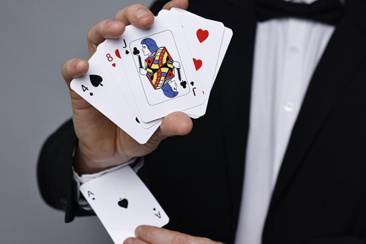 A magician removing an ace card from his sleeve
