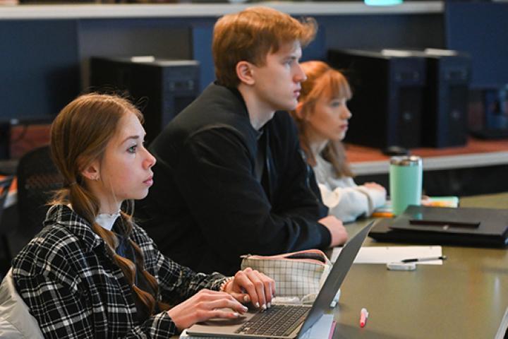 Computer Science - Software Systems a photo of 3 computer science students in a software system course classroom