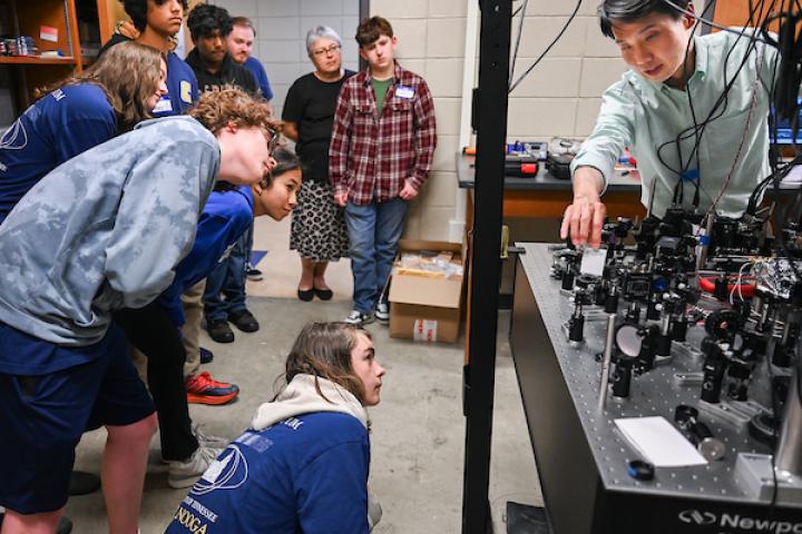 Quantum Summer Camp Students looking at quantum computing equipment as Dr. Tian Li explains its function