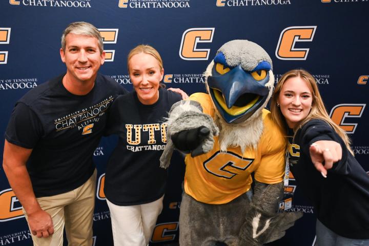 Prospective UTC family meeting with Scrappy in front of a UTC backdrop