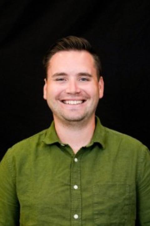 Headshot of man in green shirt