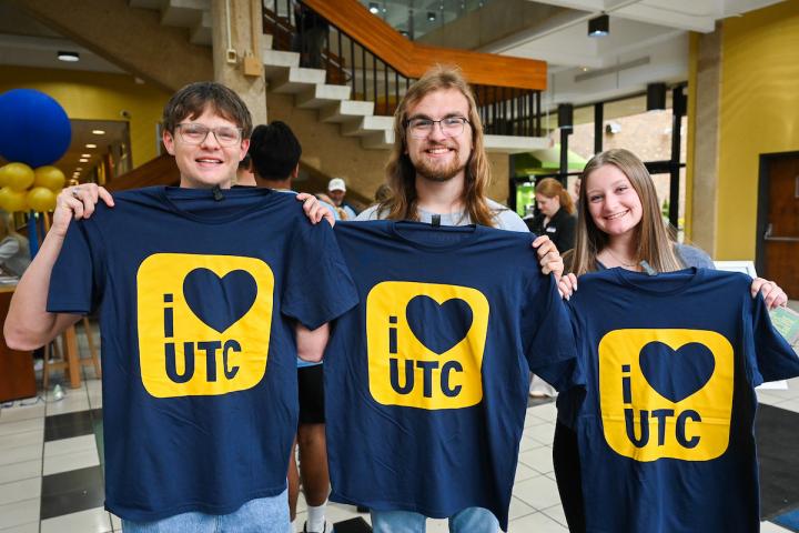 Students holding "I heart UTC" shirts