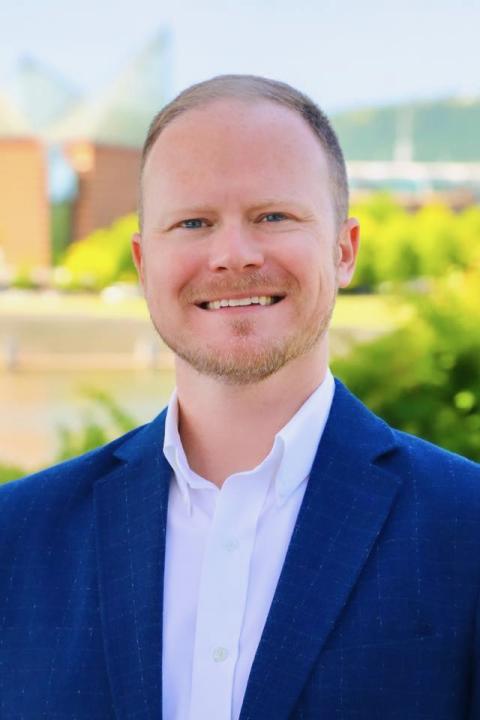 Pictre of Man with buildings behind him.