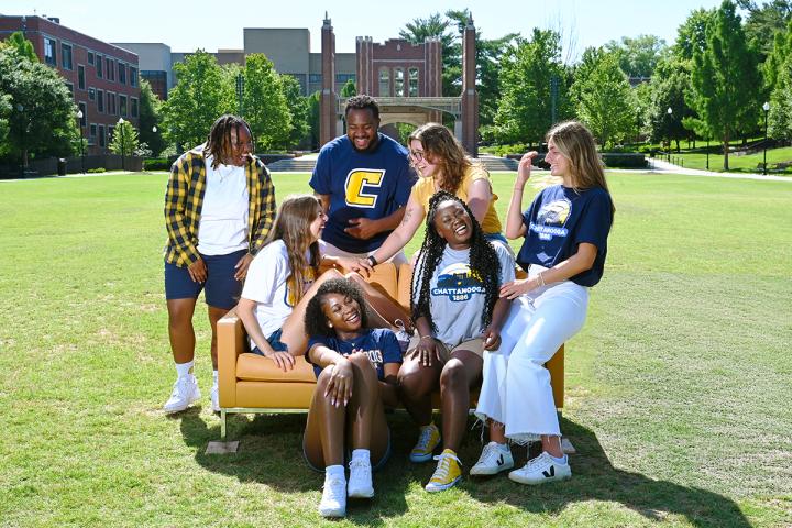 UTC students sitting on a couch on Chamberlain field