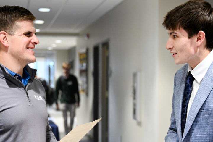Student talking to an employer at a career fair. 