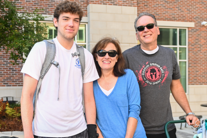 Parents and student pose for photo during operation move-in