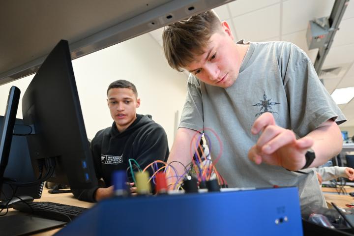 Two students working with wires for a project.