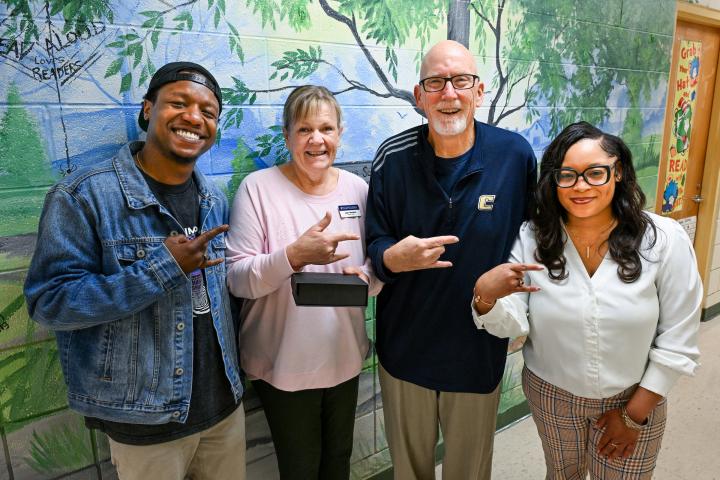 Moc’s Golden Feather Award winner Jean Walston (pink top) is joined by Children’s Center Coordinator Regis Richard, Provost Jerold Hale and Children’s Center Coordinator Jameshia Borders at Battle Academy. Photo by Angela Foster.