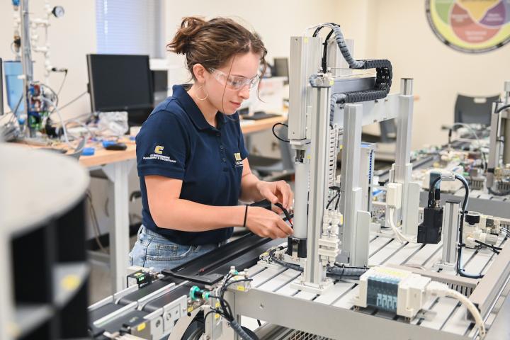 A female student working with mechanical lab equipment.