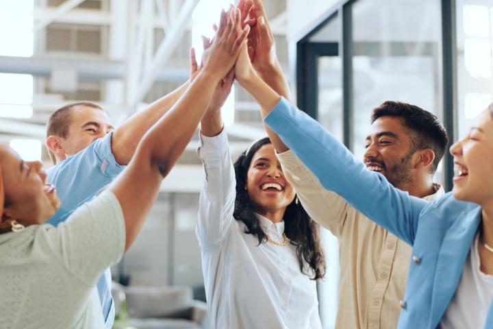 Group of professionals celebrating and highfiving