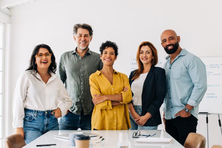 Office group photo with five professionals smiling, human resources staff