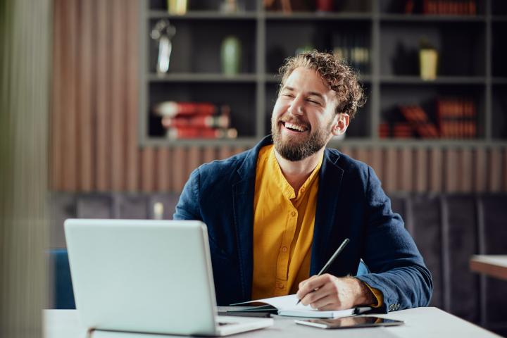 A professional man smiles in his office while using AI 