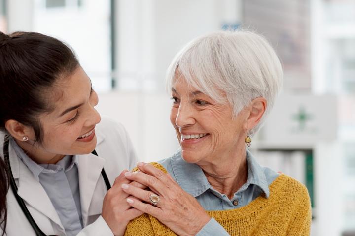A young CNA comforts and cares for an elderly patient