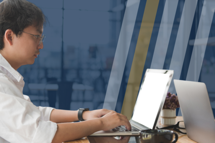 Professional man wearing glasses and typing on a computer. 