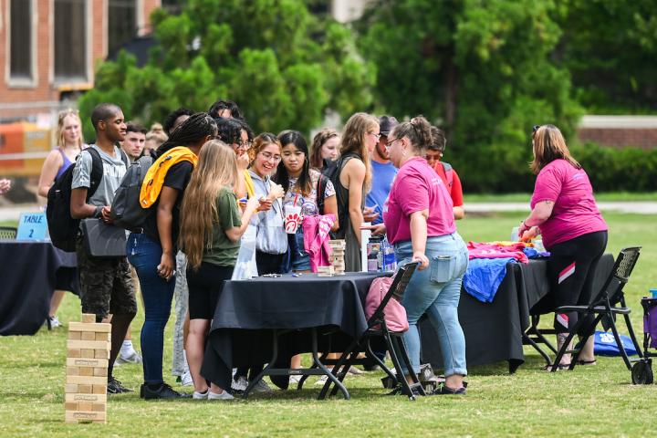Students gather around outdoor tables at UTC's Consentathon event