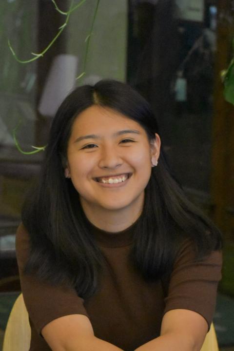 Headshot of Alisa, smiling and sitting with arms crossed