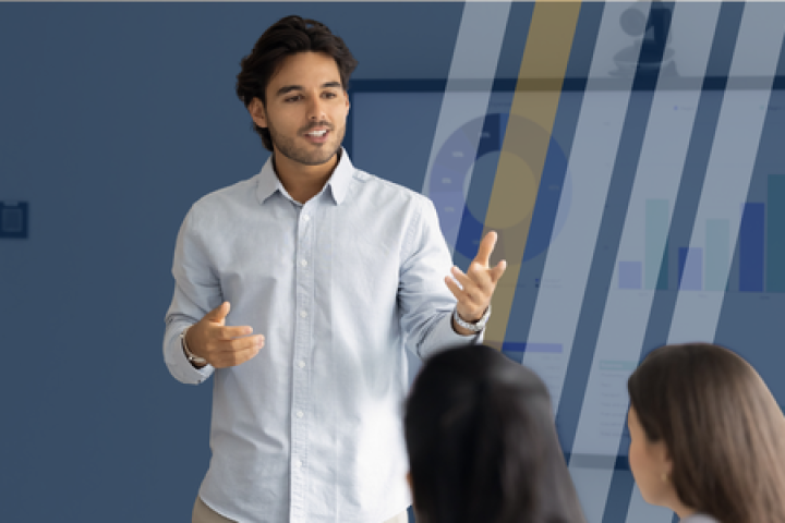 A man presents in front of a group in a business setting.