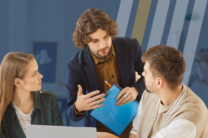 Man holds a clipboard while standing and talking to a man and a woman about business.