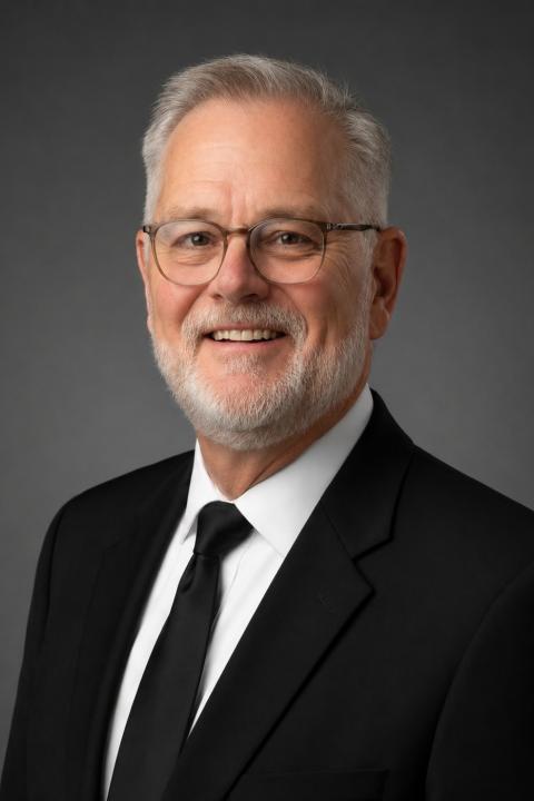 A headshot of Randall Coleman wearing a suit with a neutral background