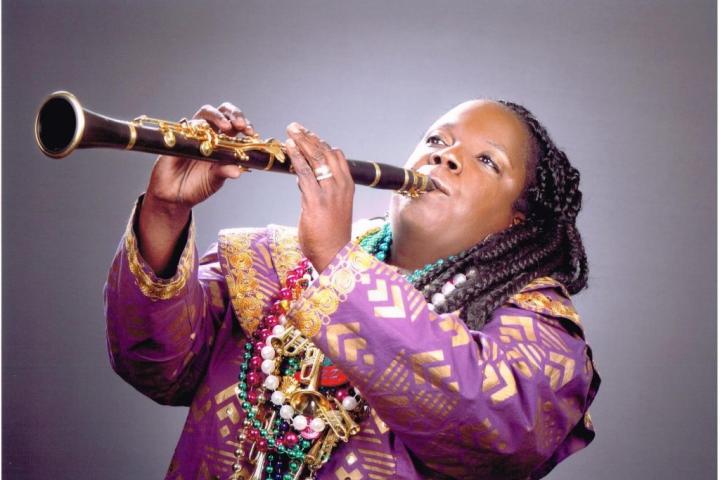 Woman playing clarinet against neutral background