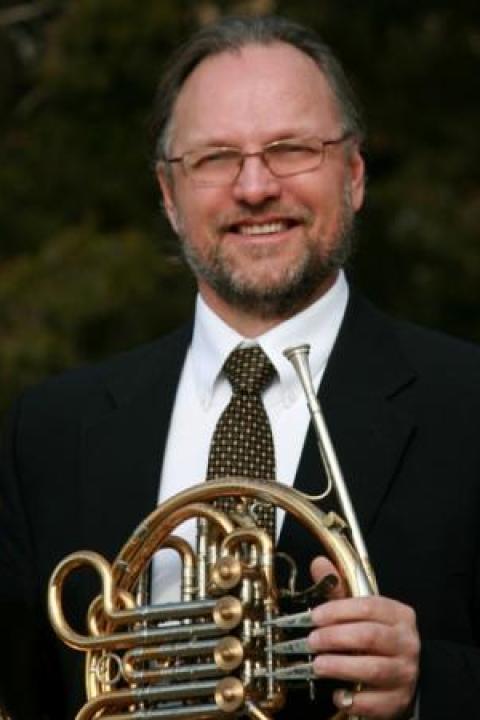 Man in suit holding Horn