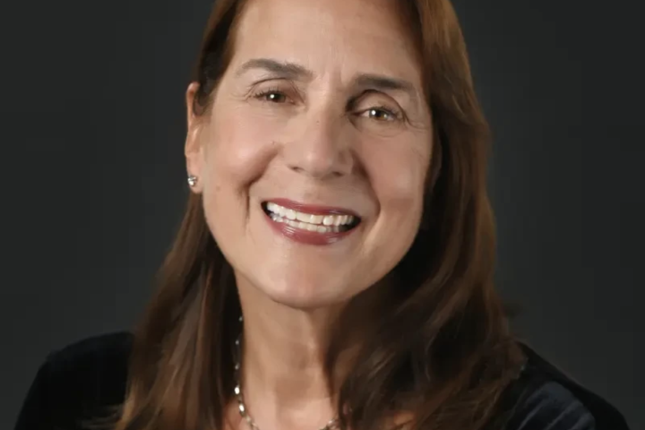 Woman smiling against dark background